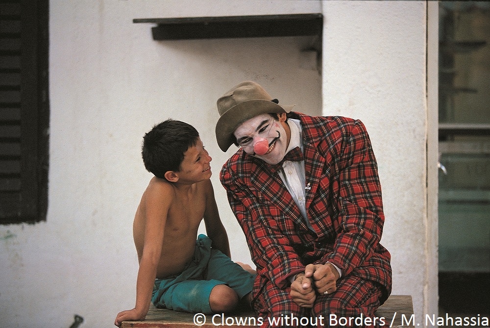 Clown making young boy in Croatia laugh