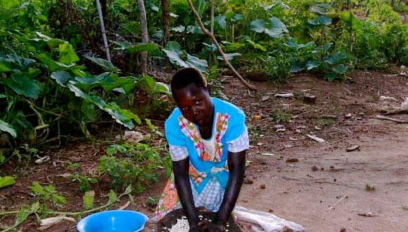 South Sudanese woman grinds maize