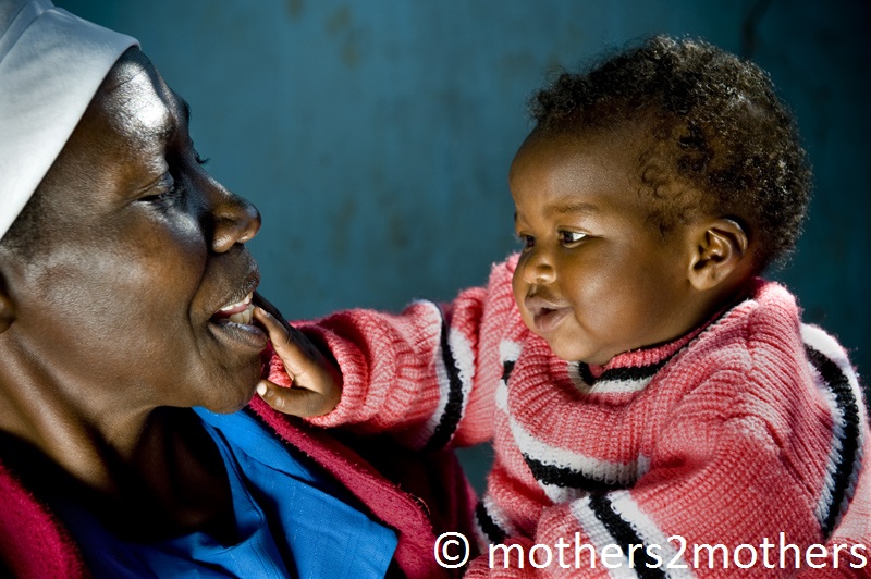 Mother holds her smiling baby