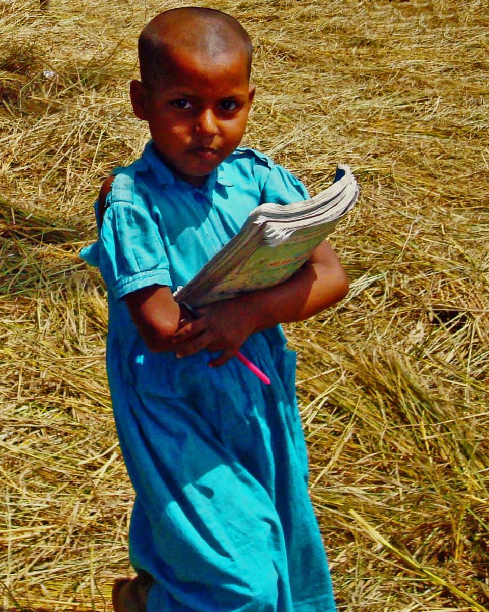 Schoolgirl in Bangladesh carrying her books