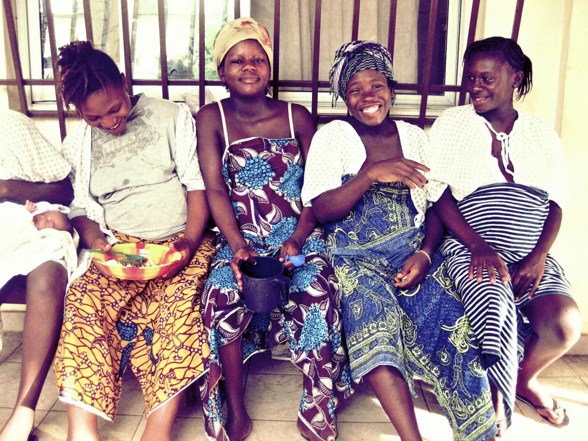 Four pregnant women sit outside the Aberdeen Women's Centre smiling