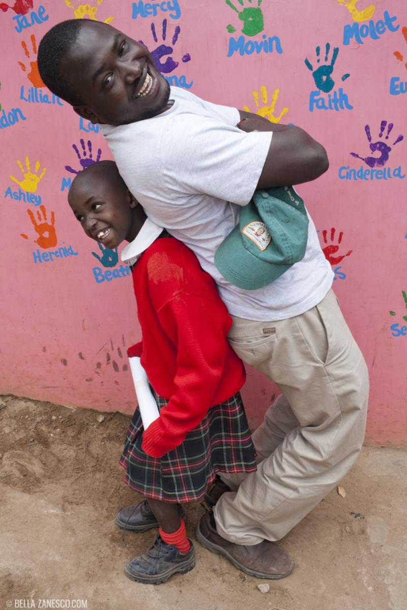 Kennedy Odede playfully poses with a girl at Kibera School for Girls