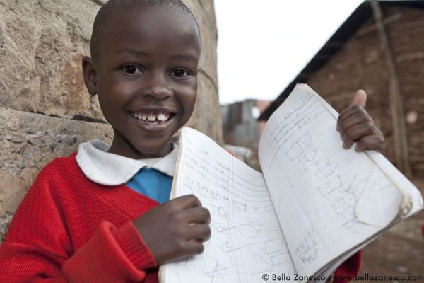 Young girl from Shining Hope for Communities' Kibera School for Girls shows off her notebook
