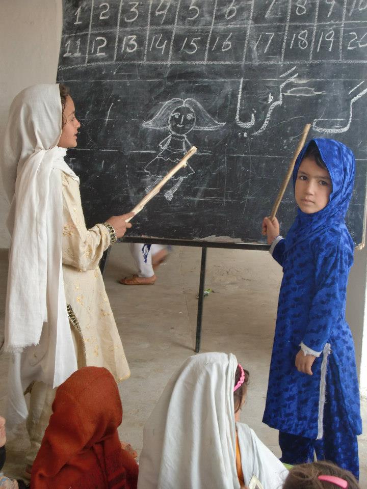 Rural girls learn in front of a blackboard in Pakistan